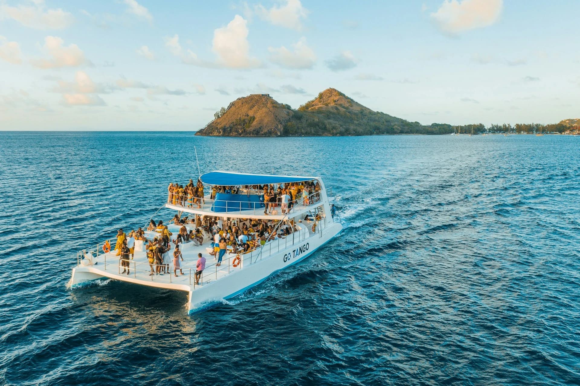 Crowd dancing on a party boat in Cancún with a DJ and open bar on the Caribbean Sea