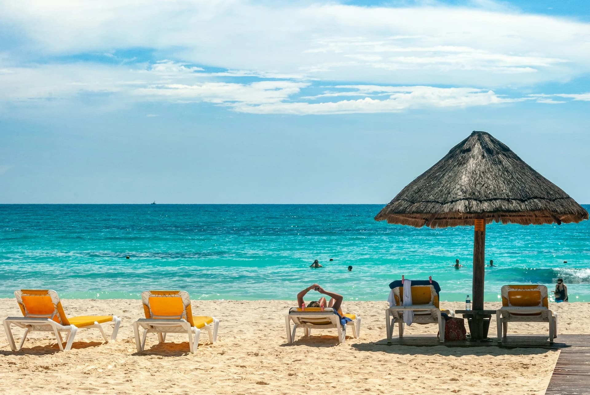 Busy white sand beach and turquoise water in Cancún Hotel Zone during peak spring break season in March