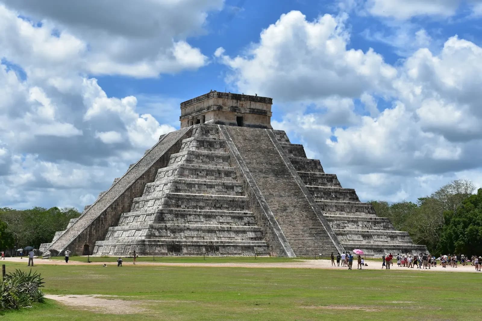 La pirámide El Castillo en Chichén Itzá iluminada con proyecciones de colores de noche durante el espectáculo Noches de Kukulkán