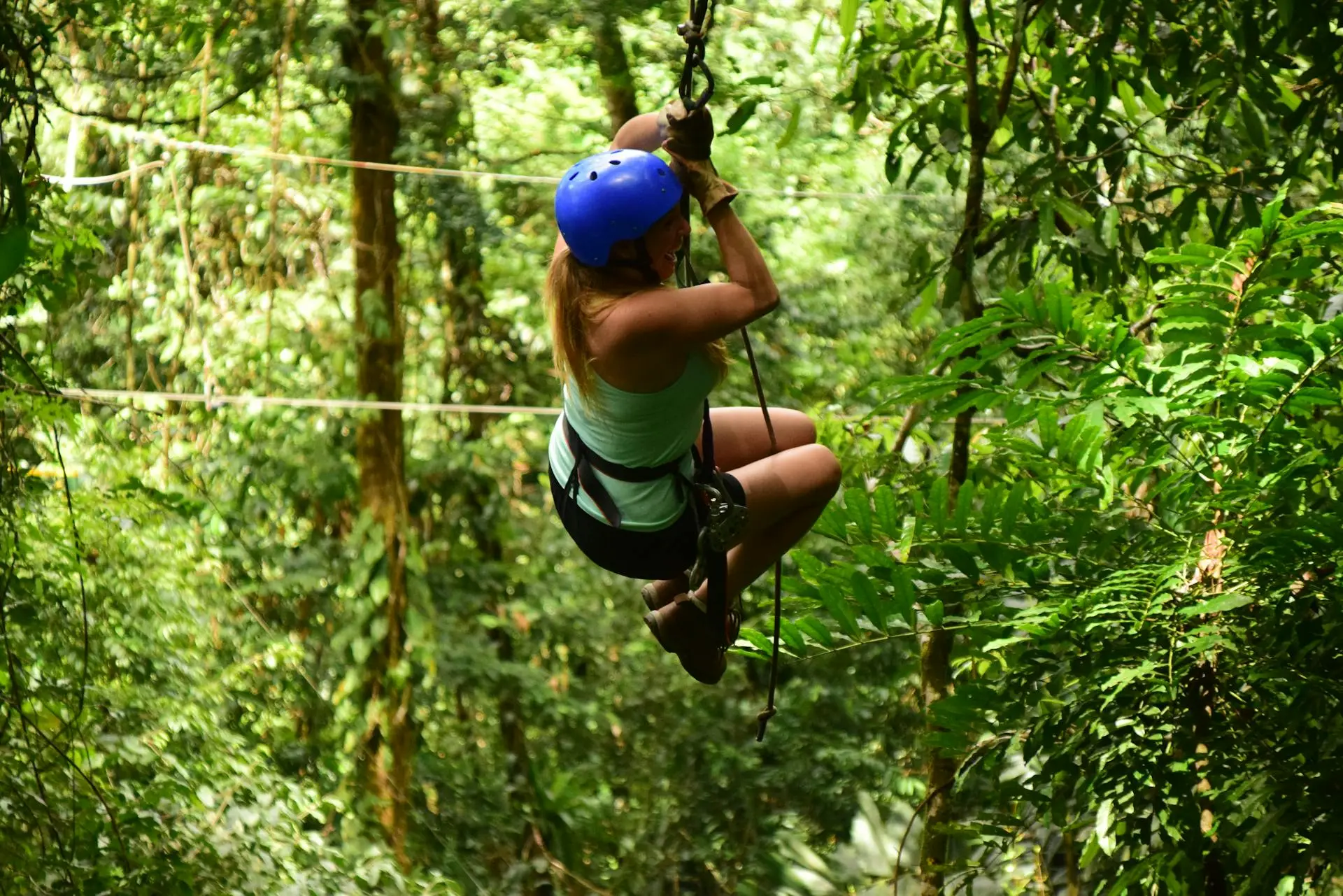 Person ziplining through the jungle canopy on a Cozumel zipline tour