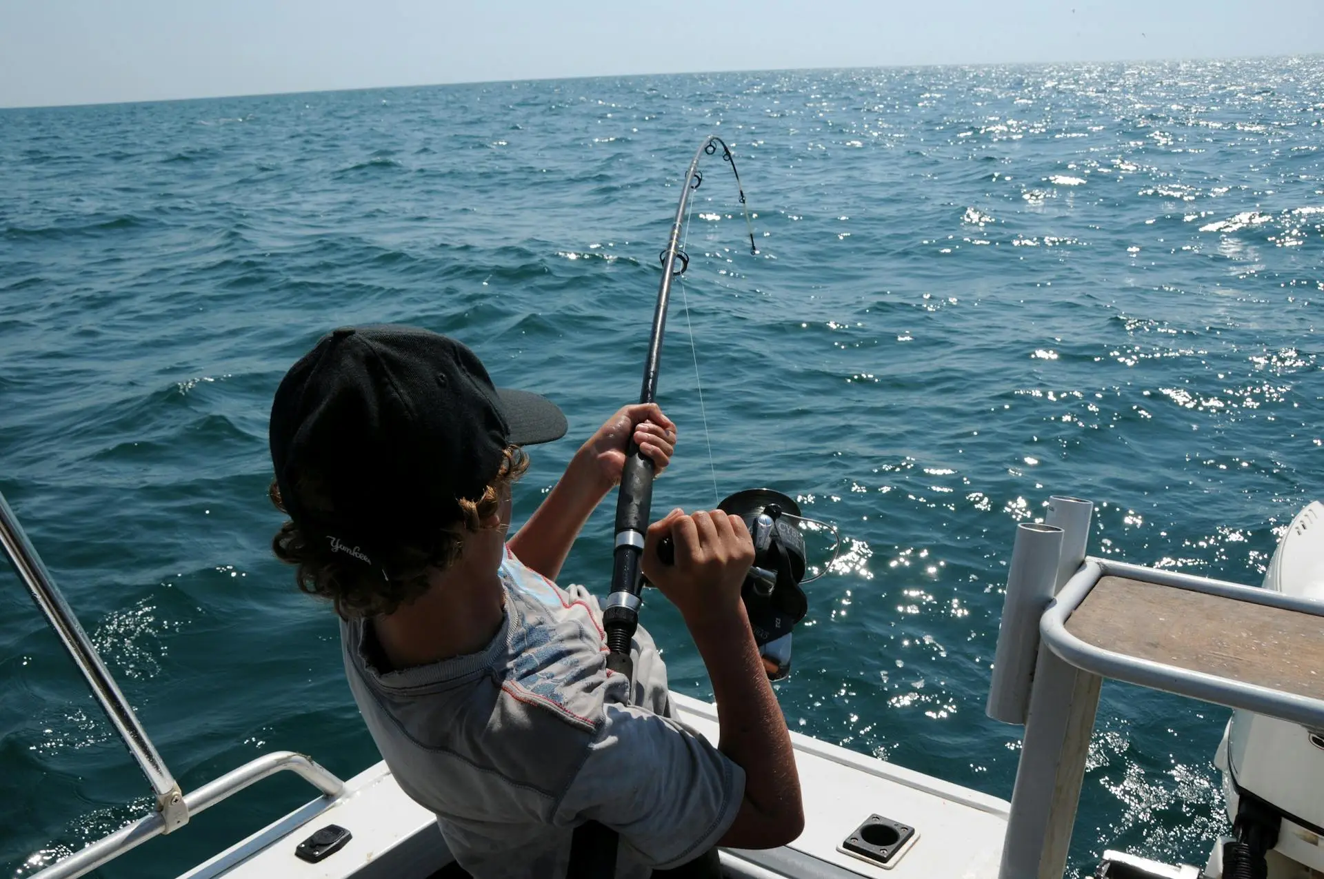 Angler holding a fresh catch on a fishing boat off the coast of Isla Holbox, Mexico