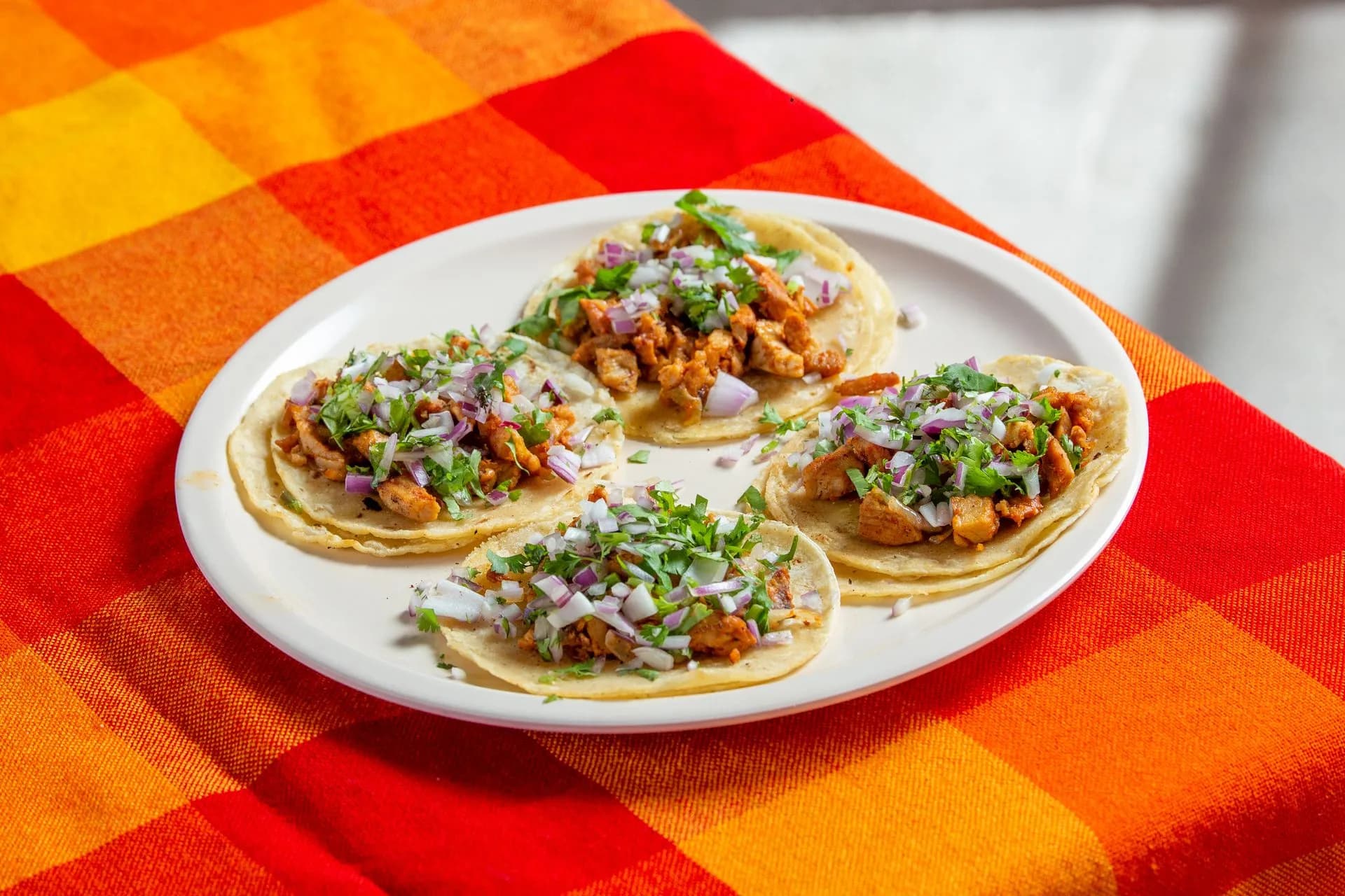 Small group on a walking food tour tasting tacos al pastor at a local taqueria in downtown Playa del Carmen