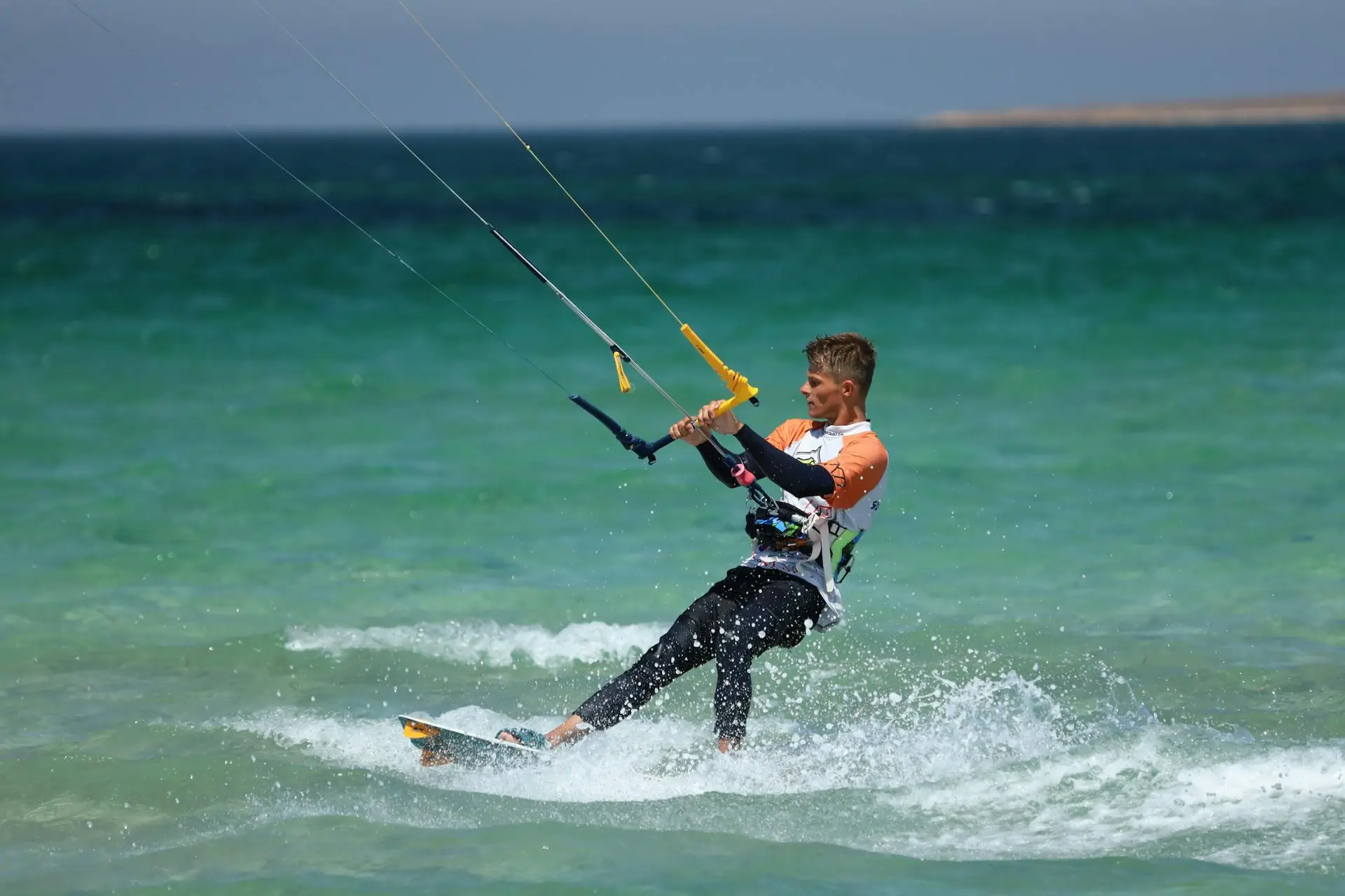 Kitesurfer launching a kite above shallow turquoise water at Playa Las Nubes, Isla Holbox
