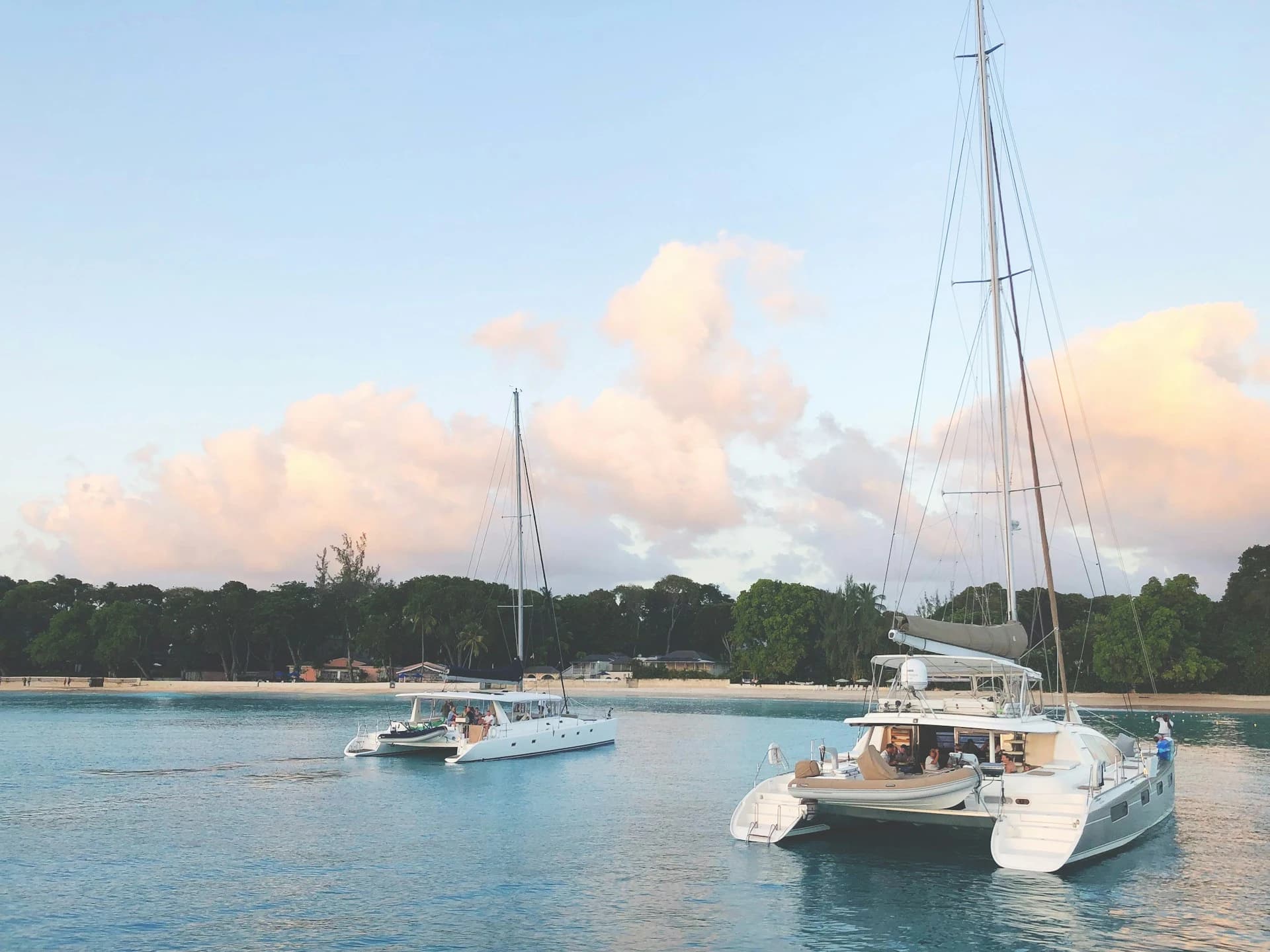 Catamarán navegando hacia el atardecer de Cancún sobre el Mar Caribe