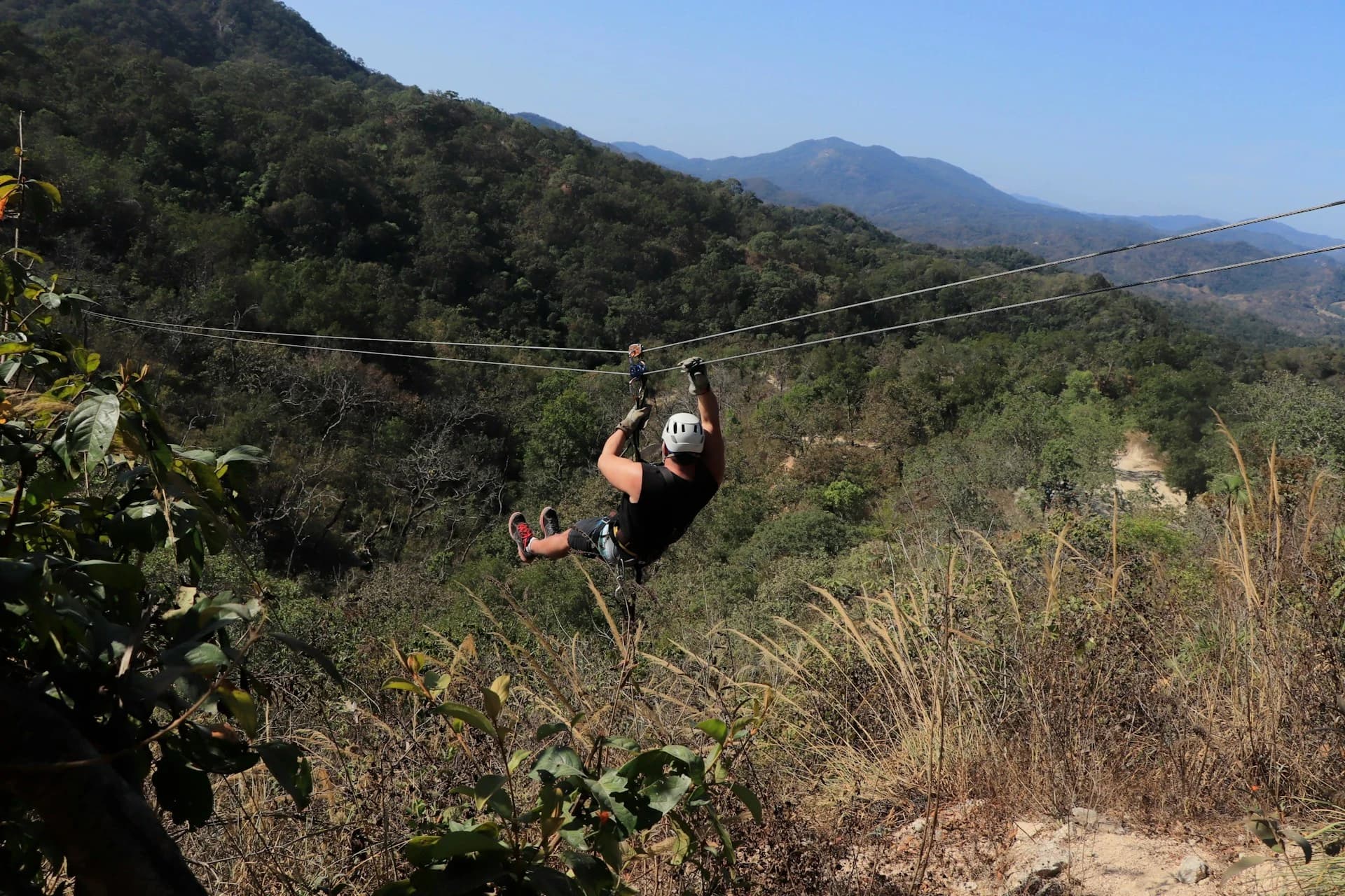 Person ziplining over the green jungle canopy near Tulum on the Riviera Maya
